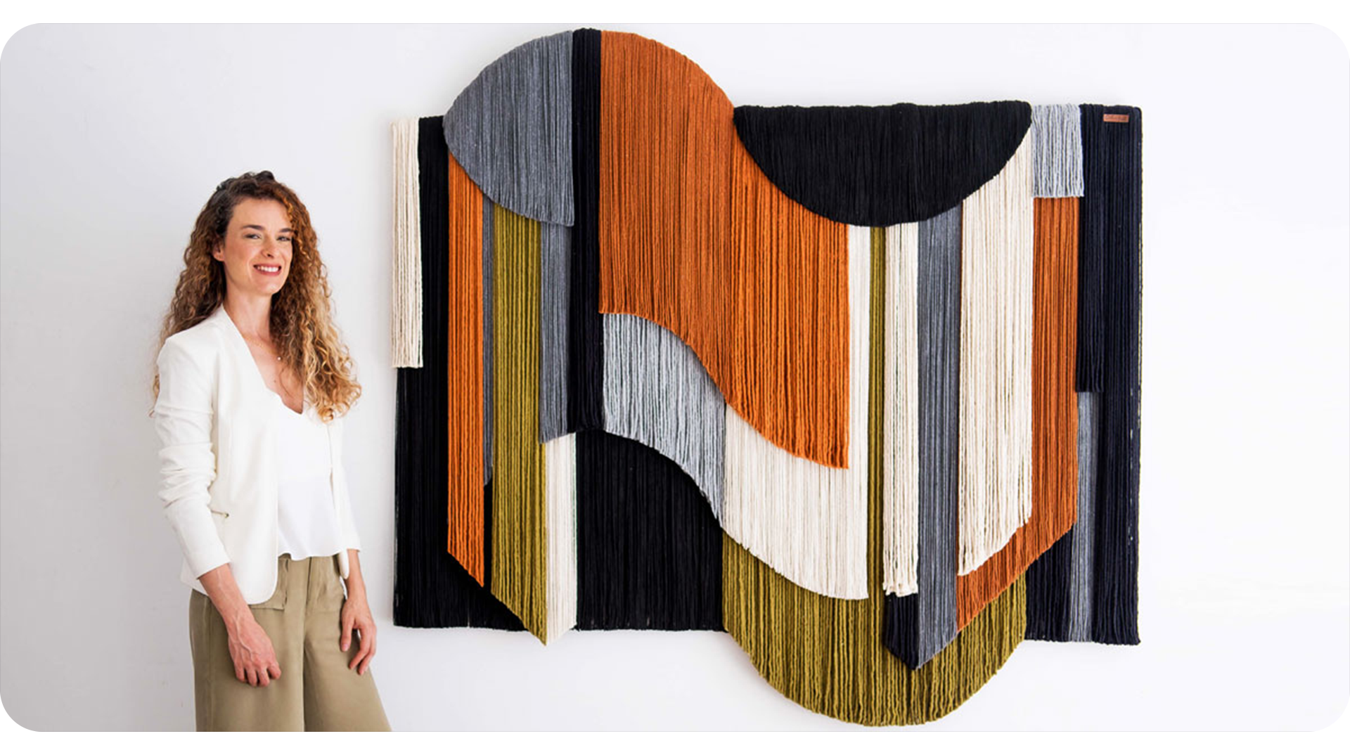 Carolina Kroff in her atelier with a hand-woven tapestry